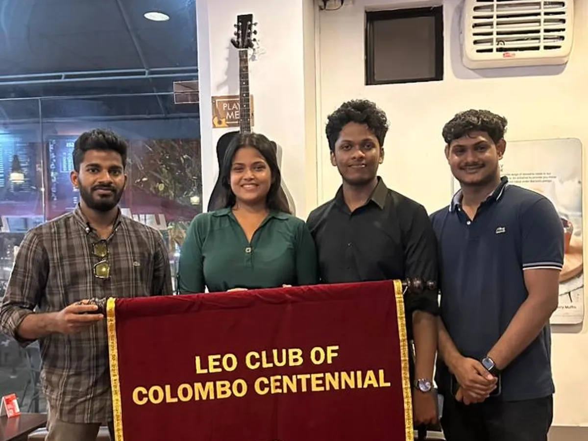 Leos holding the club banner inside the café