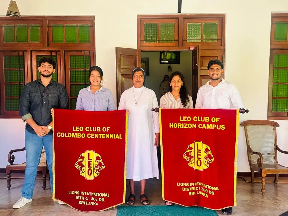 Leos and a sister of the convent holding club banners